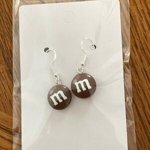 Brown M&M candy earrings.